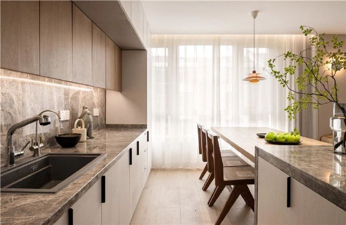 廚房與餐廳開放式的布局，空間更顯通透明亮，原木色的家具削弱了極簡風格帶來的清冷，更顯溫暖